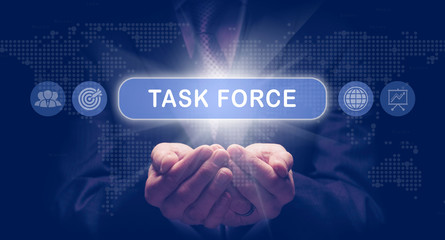 Businessmans cupped hands holding an Task Force business concept on a computerised display.