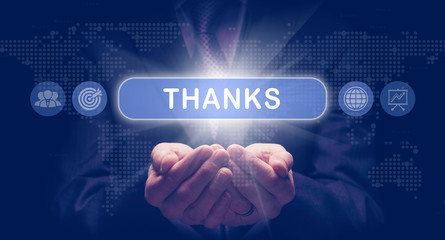 Businessmans cupped hands holding an Thanks business concept on a computerised display.