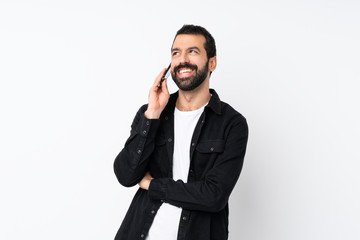 Fototapeta premium Young man with beard over isolated white background keeping a conversation with the mobile phone