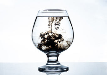 Mixing black paints with water in a transparent glass