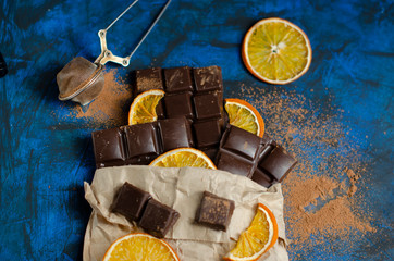 pieces of dark chocolate in a paper bag with dried oranges