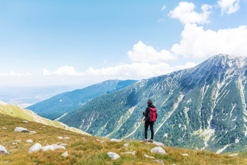 Fototapeta na wymiar Hiker Woman with Backpack on the Top of a Mountain with Stunning View.Pirin Mountain ,Bulgaria 