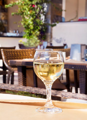 Glass of White Wine on a Table in Outdoor Restaurant 