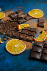 a slice of dark chocolate in cocoa powder with dried oranges