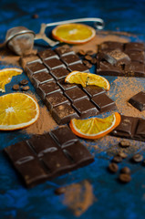 Fototapeta na wymiar a slice of dark chocolate in cocoa powder with dried oranges