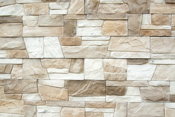 The structure of the beige wall of a beautiful ancient building. Abstract background of decorative brick wall. Copyspace