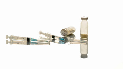 2 Medical syringe with an injection needle, a bottle of medicine on a medical table.