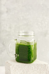 Green smoothie from broccoli, spinach, kiwi and banana on a light background. Eco concept. Healthy green smoothie and ingredients on white - superfoods, detox, diet, health, vegetarian food concept.