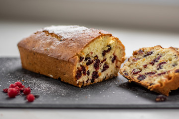 Orange pound cake with cranberries on a black stone plate