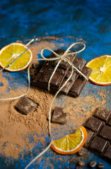 a bar of dark chocolate with pieces of orange tied with a thread