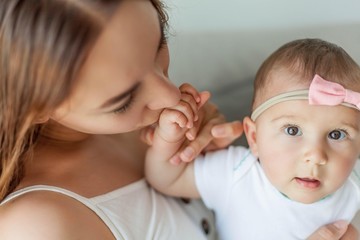 Young happy mother with her daughter in the home interior. Mothers Day.