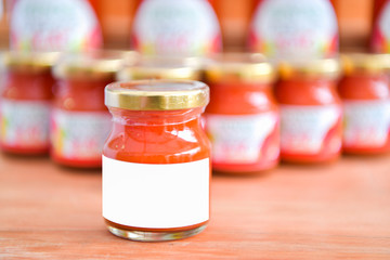 Ketchup in a glass jar and the white paper.