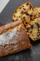 Orange pound cake with cranberries on a black stone plate