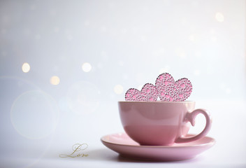 Obraz na płótnie Canvas Pink porcelain cup of tea with icons of two pink hearts and word LOVE