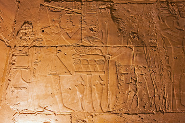 Hieroglyphic carvings on an ancient egyptian temple wall at night