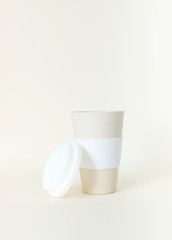 Reusable thermos Cup in beige color on a beige background. Monochrome.
