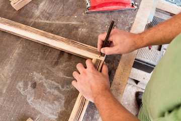 Male carpenter working on old wood in a retro vintage workshop.