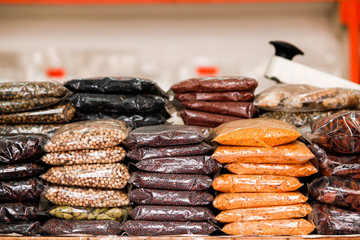 Spices and dry fruits in plastic packaging kept on display for sale