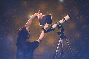Man looking at the stars through a telescope- astrology concept, horoscope predictions about the future. © astrosystem