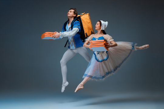 Modern Cinderella and prince hurrying up, deliverying pizza. Young and graceful ballet dancers on studio background. Art, motion, action, flexibility, inspiration concept. Fast order's delivery.