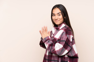 Young Indian woman isolated on beige background scheming something