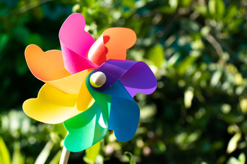 Colorful toy plastic turbine windmill on green background