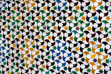Fototapeta na wymiar Colorful geometric patterns on traditional tiles, house wall in Spain. Artistic background.