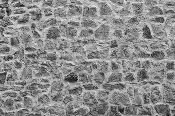texture of gray stone wall close up , black and white old bricks background macro , monochrome ancient bricklaying surface backdrop