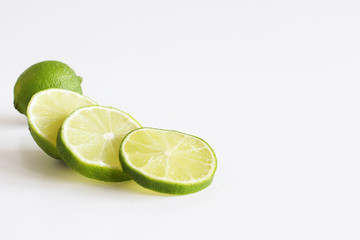 Lime. Fresh fruit isolated on white background. Slice, piece, half, quarter. Rich of nutrients, fibre, and vitamins. Picture design for foods background. From top view.