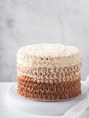 Birthday buttercream chocolate cake on vintage white table behind light wall background, copy space. Celebration wedding concept. Trendy vintage Cake.