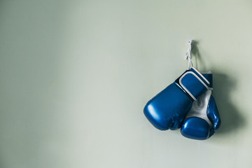 old boxing gloves hanging on a nail