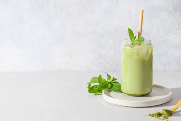 Iced Green matcha tea in glass garnish mint isolated on white table. Space for text. Close up. Horizontal orientation.