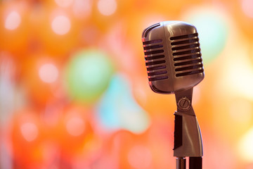 Fototapeta na wymiar Retro microphone on orange background of restaurant lights