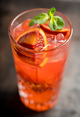 Red cocktail with blood oranges and mint on the rustic background. Selective focus. Shallow depth of field.