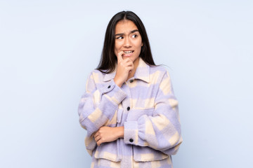Obraz premium Young Indian woman isolated on blue background nervous and scared