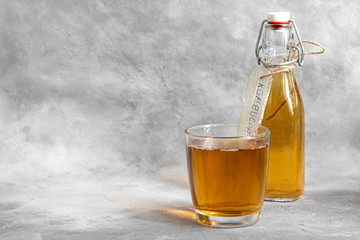 Kombucha or cider, fermented drink on a gray background. A probiotic healthy drink is Kombucha.