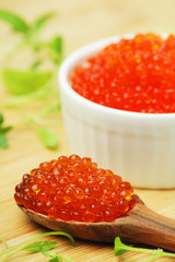 A small ceramic bowl with red caviar