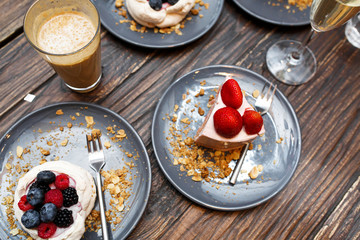 Sweet cakes with summer berries on a wooden table. Party, sweet table. Summer offer desserts in the restaurant.