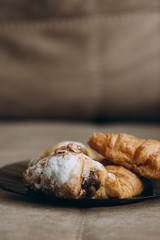 wedding rings lie on warm croissants sprinkled with powdered sugar