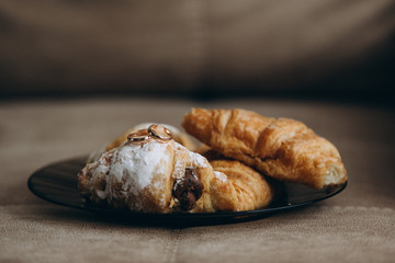 wedding rings lie on warm croissants sprinkled with powdered sugar