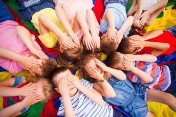 Children laying very closely, covering face by hands