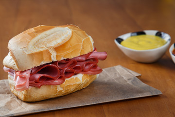 traditional brazilian mortadella sandwich on wooden background