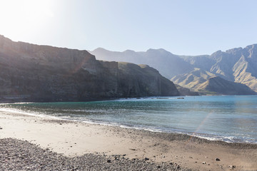 small beach in a Canarian town with large mountains in the background