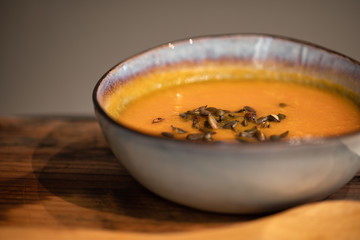 pumpkin carrot soup in a bowl on a wooden table, home made soup. healthy food close-up