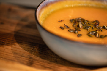 pumpkin carrot soup in a bowl on a wooden table, home made soup. healthy food close-up