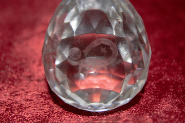 Scorpio and stars inside a transparent faceted abstract crystal on a bright red background.