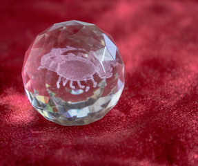 Scorpio and stars inside a transparent faceted abstract crystal on a bright red background.