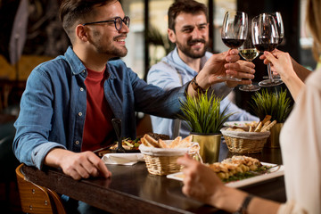 Group of young people having dinner in the restaurant