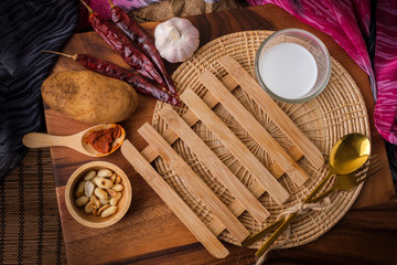 Wooden heating pad with a glass of milk and spoon and fork with blank text space.