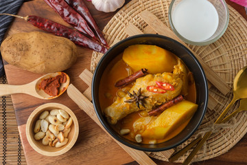 Massaman Curry With Chicken and Thai herbs with wood background texture
